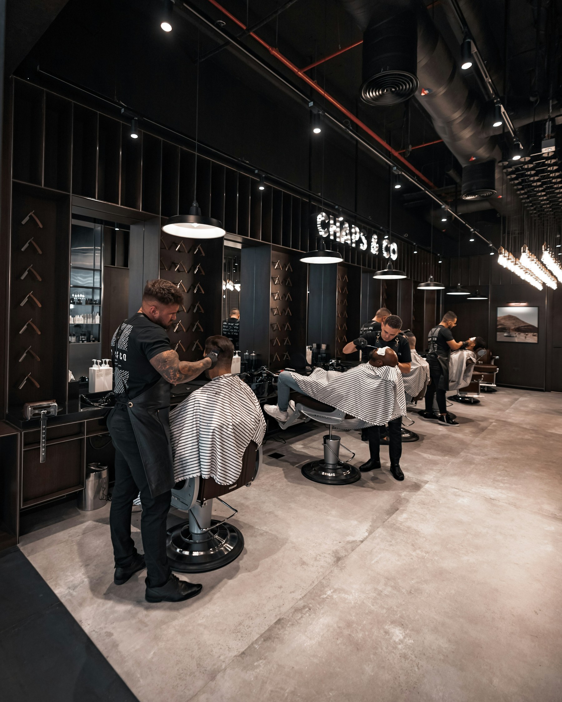 Barbers working with clients in a modern studio