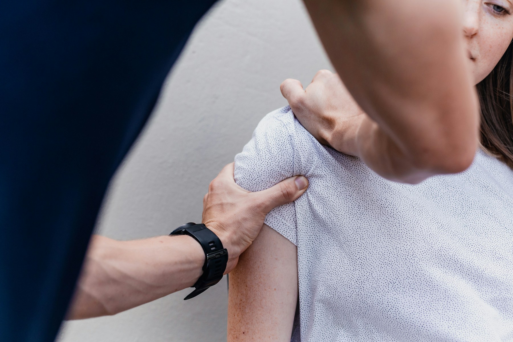 Physiotherapist assessing a patient's shoulder